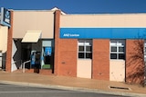 A brown brick building with blue ANZ signage on a main street in regional SA