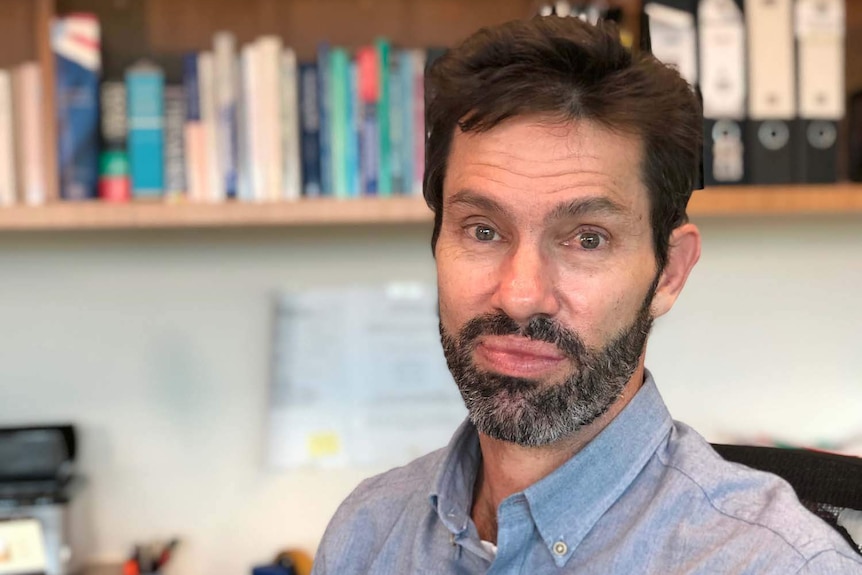 Headshot of Professor David Whiteman looks at the camera in his Brisbane office.