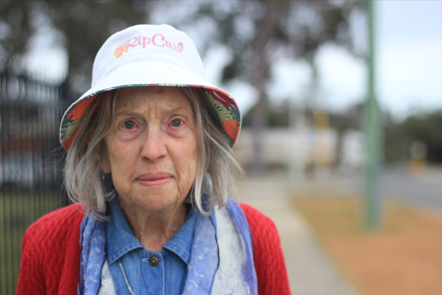An elderly woman in a white bucket hat