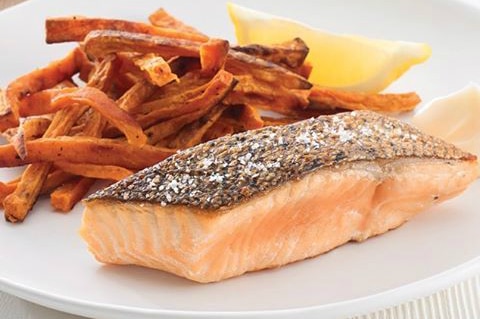 piece of cooked salmon on a plate with sweet potato chips