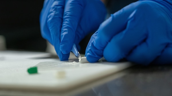 A scientist testing a pill-like substance.