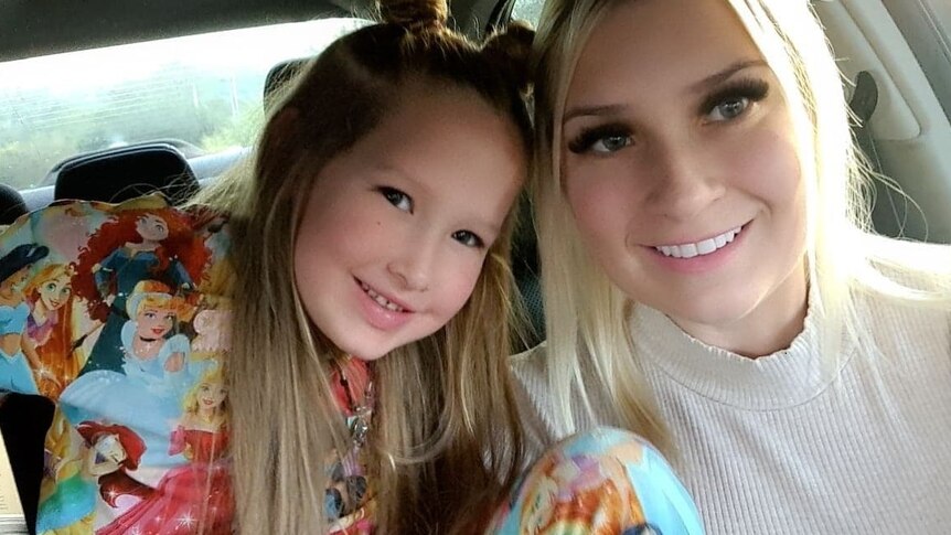 Blonde haired woman with young girl, both smiling