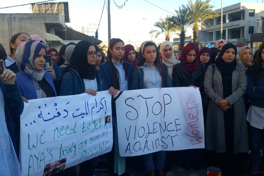 The community of Baka al Gharbiye holding up signs.