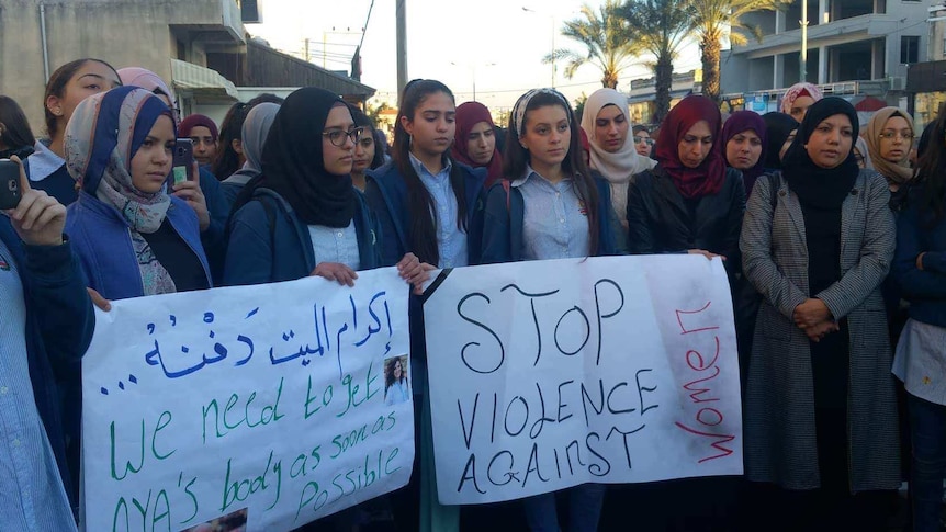 The community of Baka al Gharbiye holding up signs.