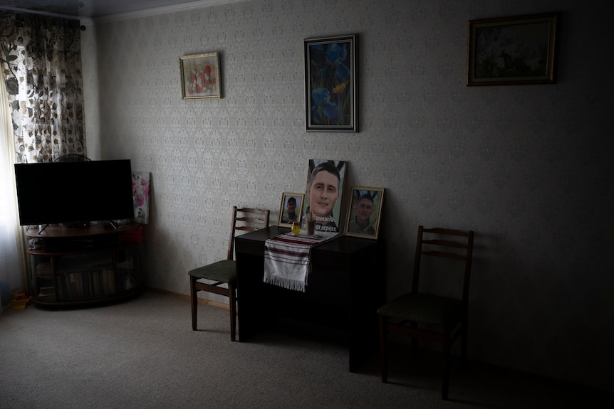 Photos of Yurii Stiahliuk sit in the living room of his parent's apartment in Bucha