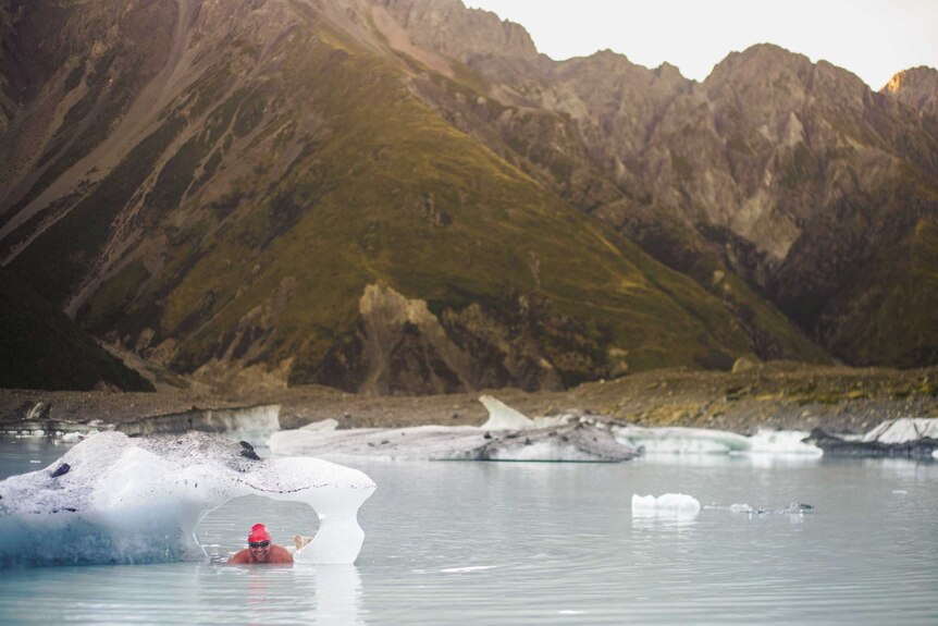 A man swimming through an iceberg