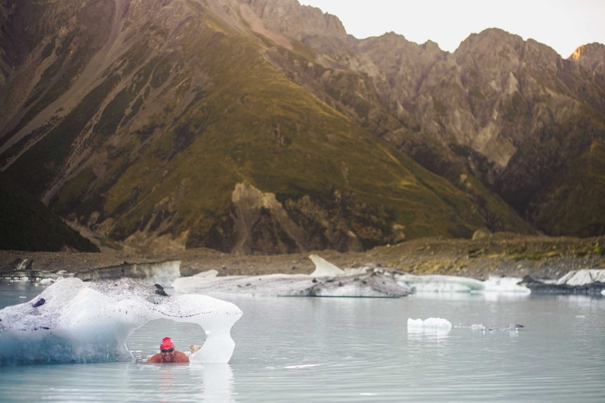 A man swimming through an iceberg