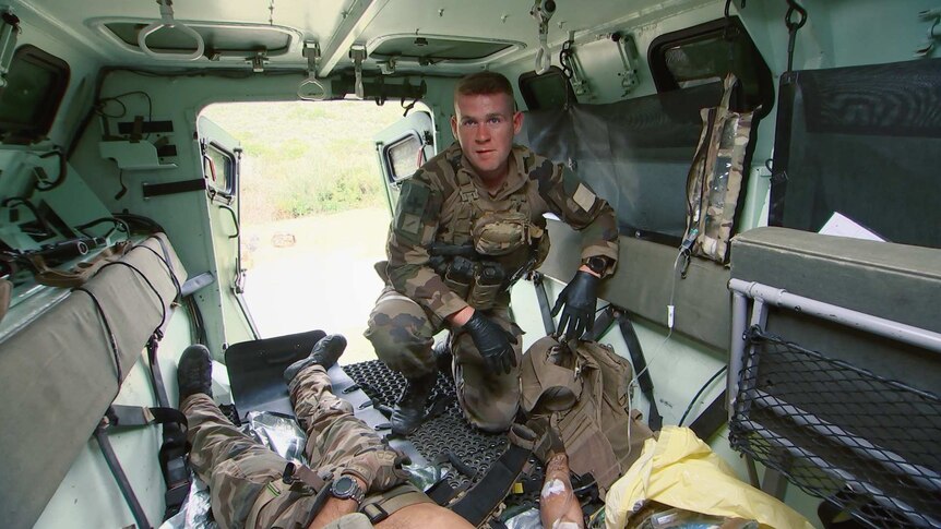 First Class Legionnaire Scott works on a casualty in the back of an armoured personnel carrier.