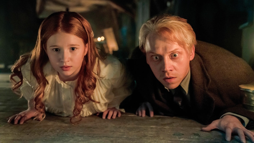 Rupert Grint and a young girl crouch down, looking scared, in a still from Guillermo del Toro's Cabinet of Curiosities.