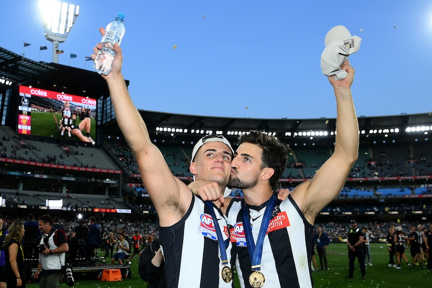 Josh Daicos kisses Nick Daicos on the cheek as they salute the crowd