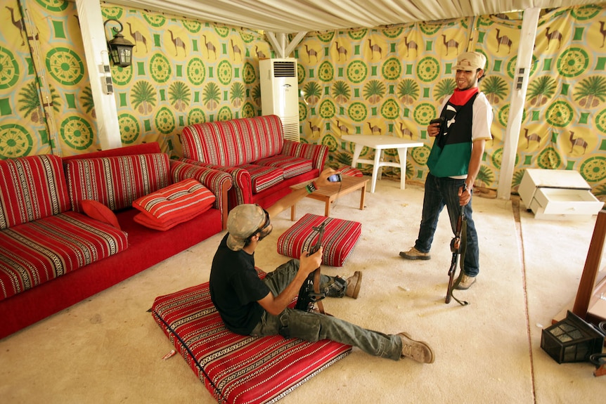 Rebels take souvenir pictures inside the tent where Gaddafi used to receive foreign dignitaries at his compound in Tripoli.