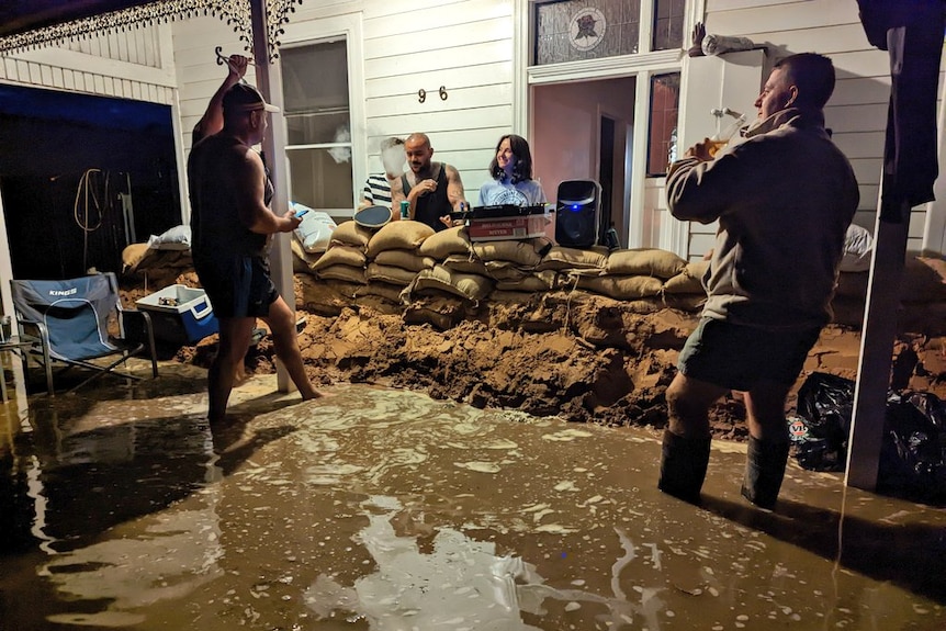 A DJ performing in a flooded front yard