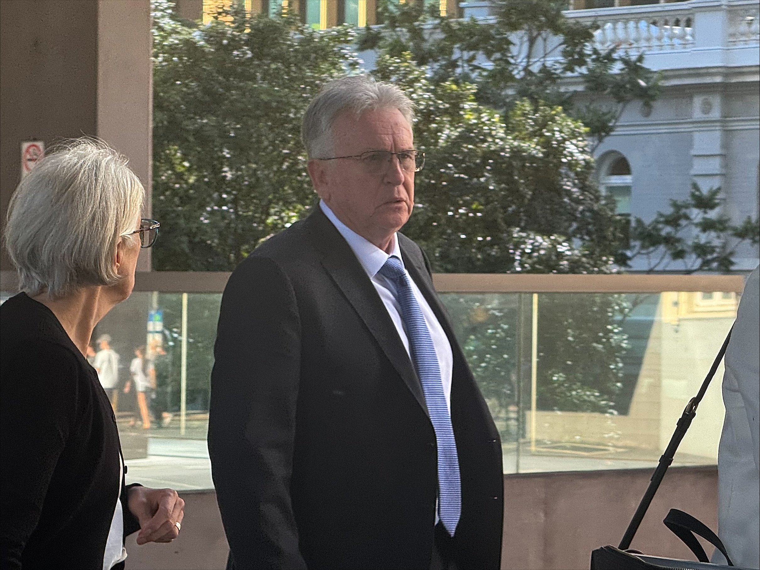 a man leaves brisbane magistrates court wearing a suit