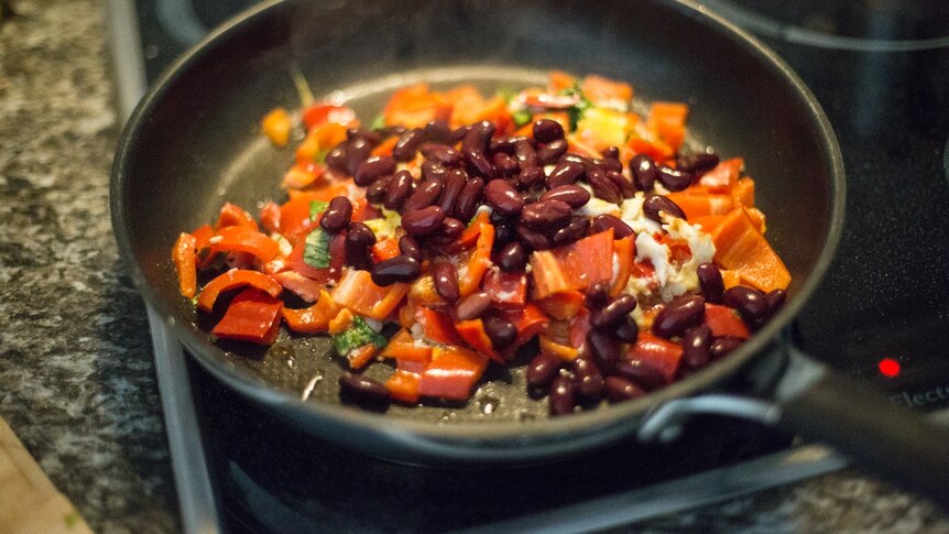Kidney beans and red capsicum frying in a pan