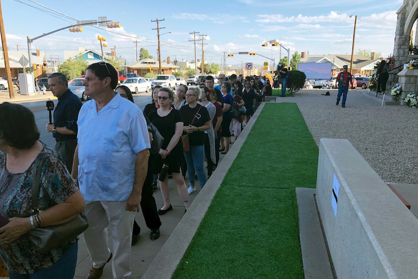 Mourners wait in line for the funeral of Margie Reckard