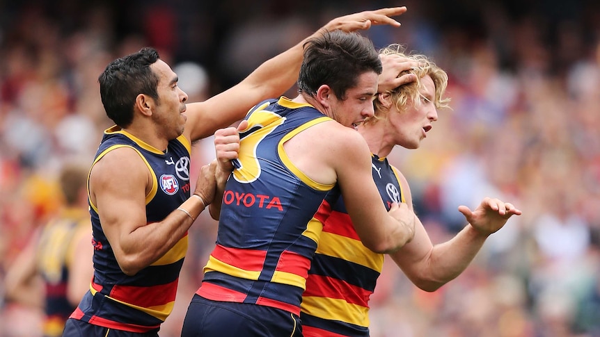 Adelaide's Rory Sloane (R) is congratulated by team-mates after his goal against St Kilda.
