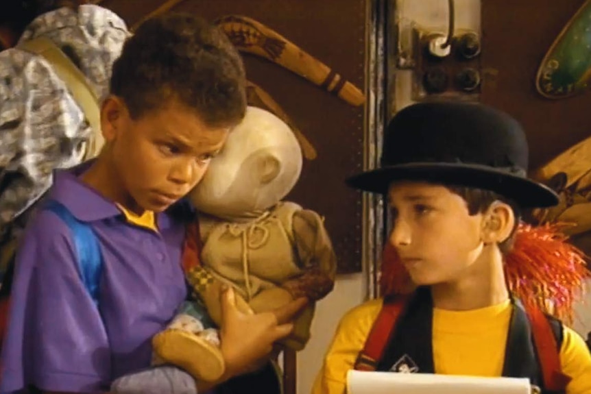 Two young boys with the faceless doll