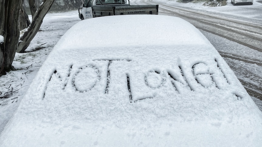 Car windscreen with the words Not Long written in snow. 