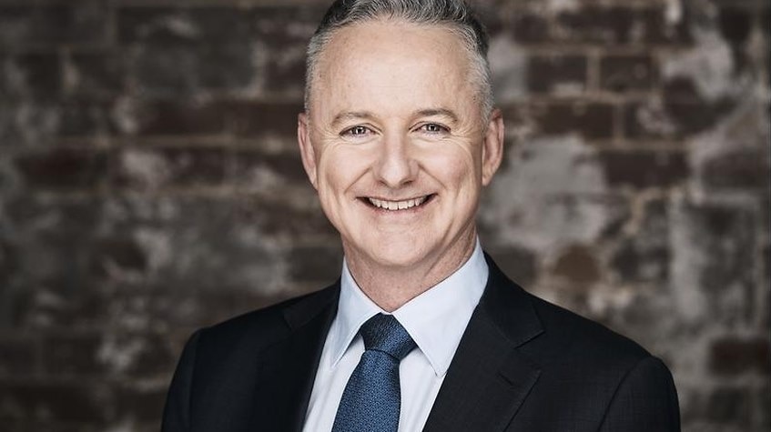 Hugh Marks smiles while wearing a suit