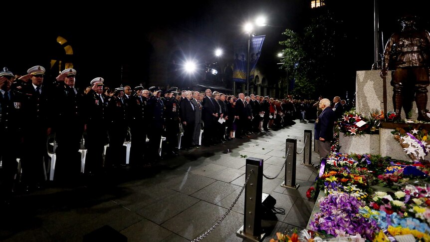 Flowers and tributes are seen on the cenotaph during the Anzac Day dawn service in Sydney, Saturday, April 25, 2015.