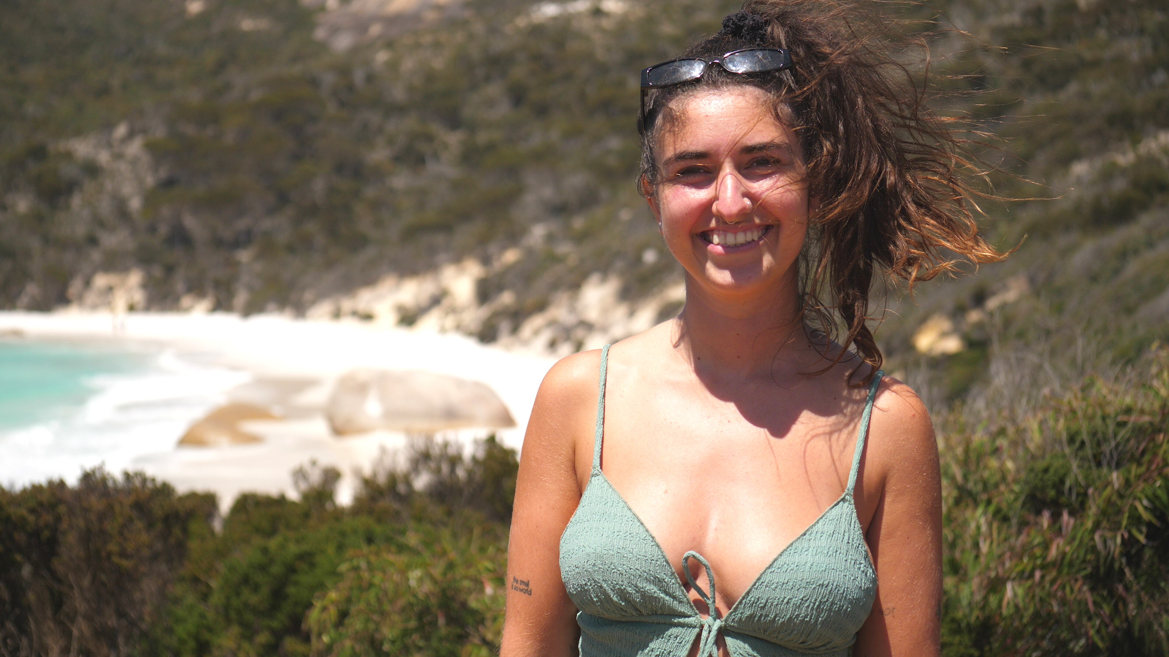 A smiling young woman at a beach.