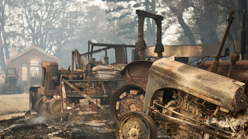 A scene of heavy machinery and buildings destroyed by bushfires.