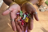 A close of woman's hand holding paper birds