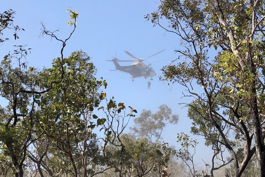 A man being winched by a helicopter.