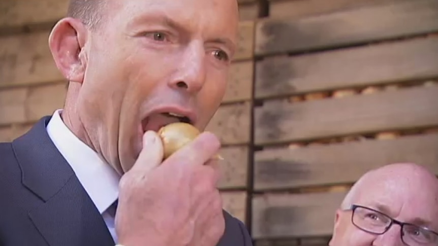 Tony Abbott eats a raw onion