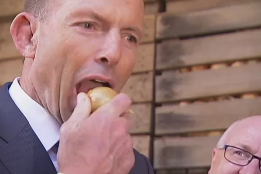 Tony Abbott eats an onion