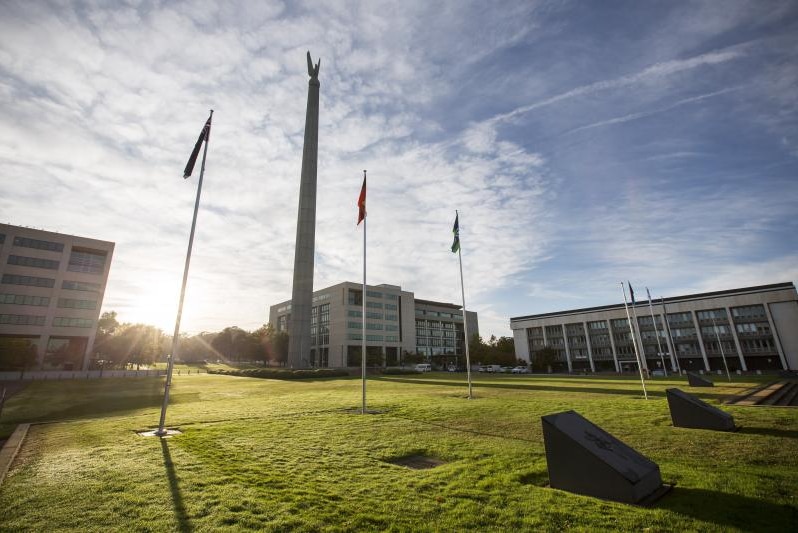 The lawn of the Russell Offices complex, with the sun rising over the top.