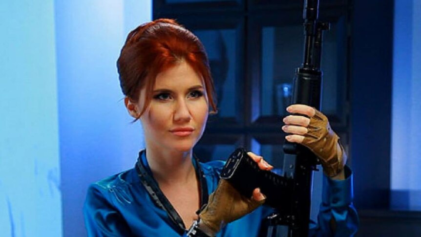 Russian spy Anna Chapman poses with an automatic rifle in a futuristic model shot.