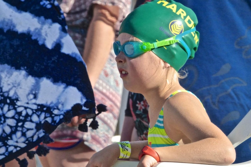 A young girl watches a swimming race in Jugiong, NSW.