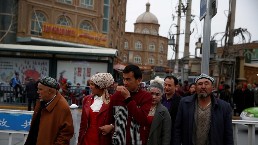People cross a street in the old town of Kashgar.