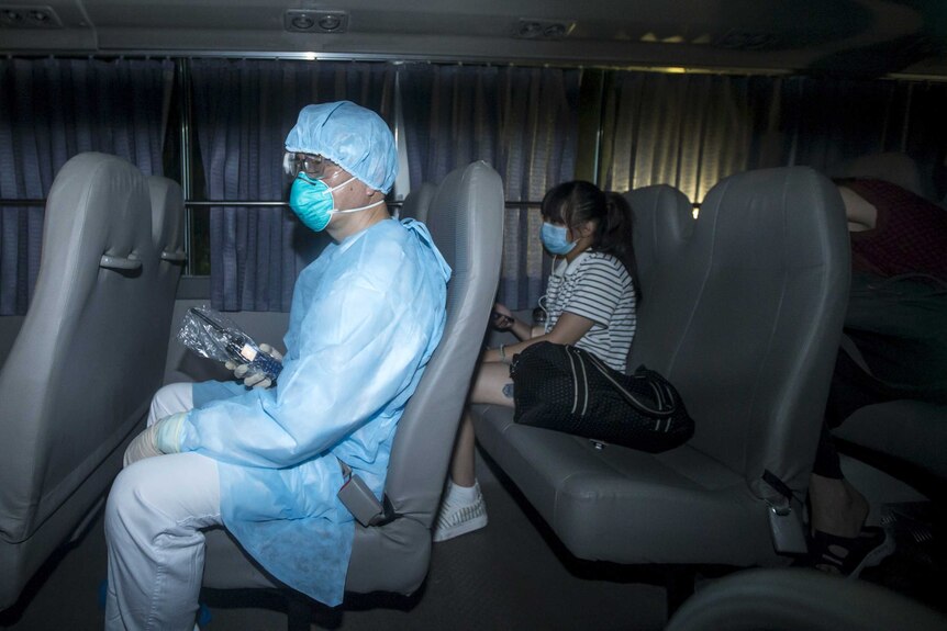 A health worker escorts someone who had come into close contact with the MERS virus to quarantine