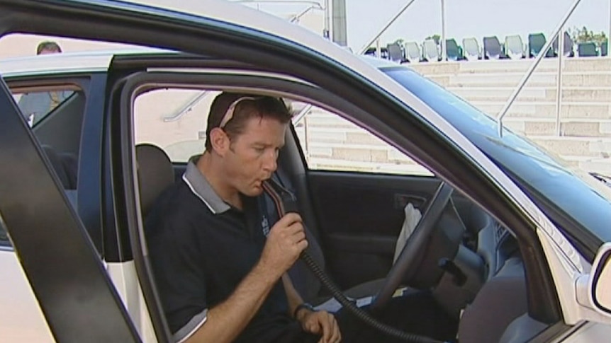 A man using an alcohol interlock device.