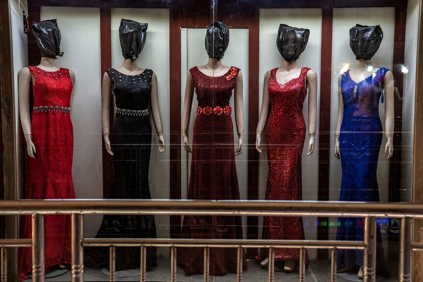The heads of mannequins are covered by plastic bags in a women's dress store store in Kabul.