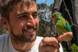 Dr Dejan Stojanovic holds a swift parrot