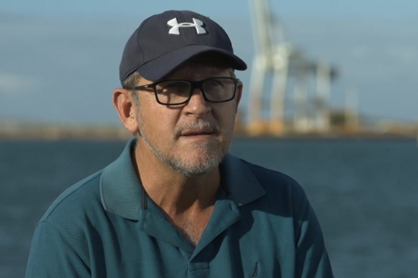 Sam Cox wears a blue cap and green shirt