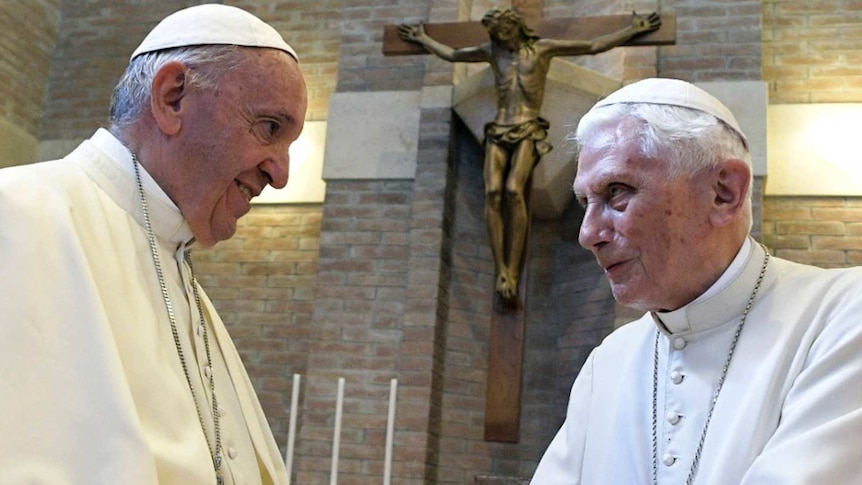 Pope Francis, left, and Pope Benedict XVI, right, meet each other, both in white.