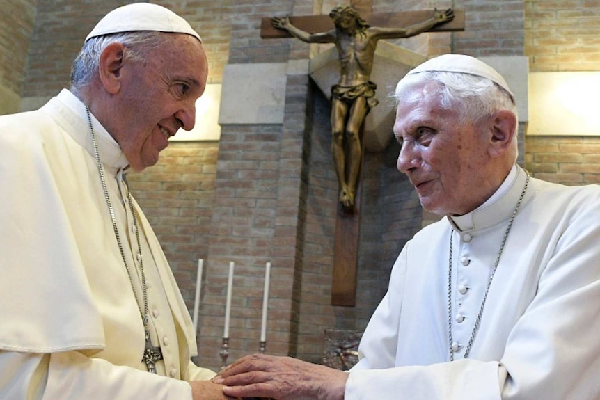 Pope Francis, left, and Pope Benedict XVI, right, meet each other, both in white.