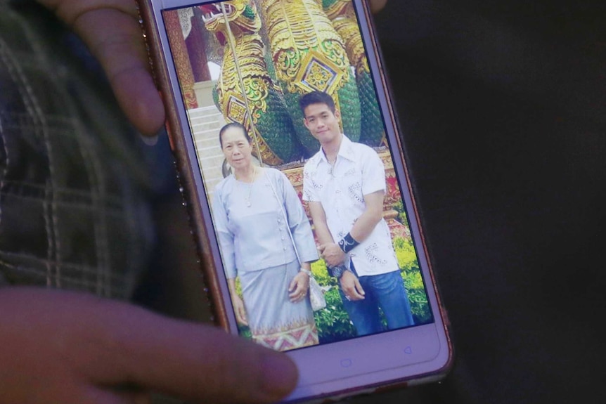 A mobile phone screen shows a photo of Ekapol Chanthawong and his grandmother.