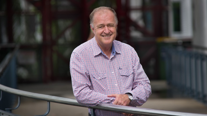 Professor Gerry FitzGerald leaning on a railing outside, smiling