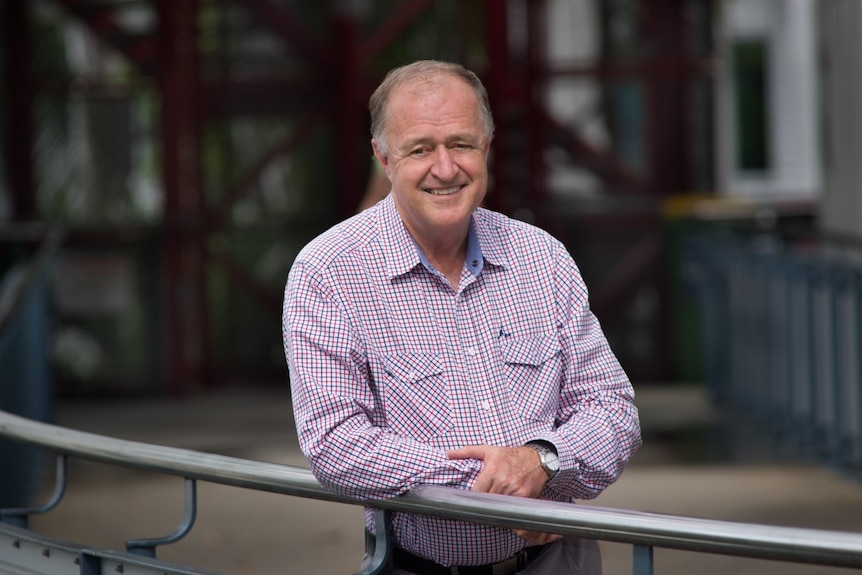 Man standing at a rail smiling