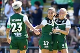 Canberra female football players celebrating.