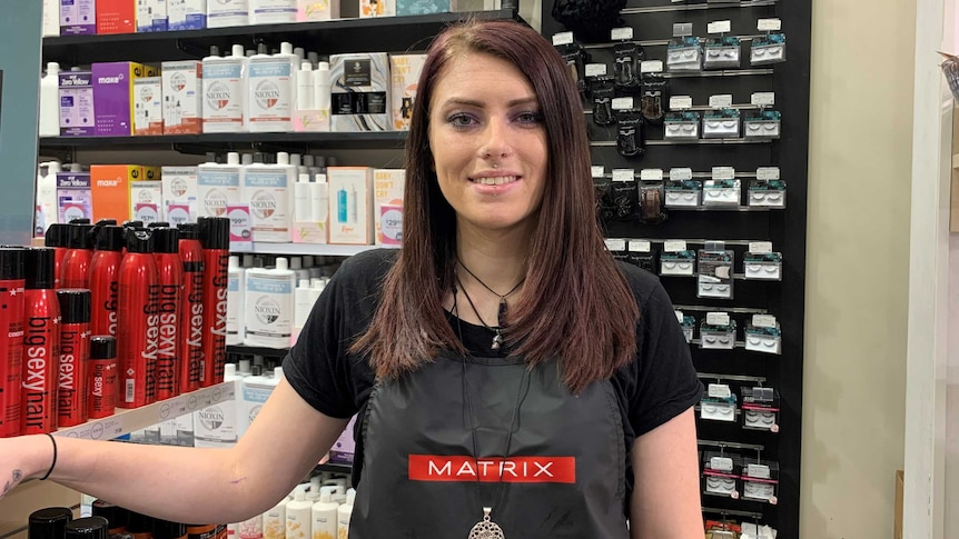 A woman wearing an apron at a hairdressing salon