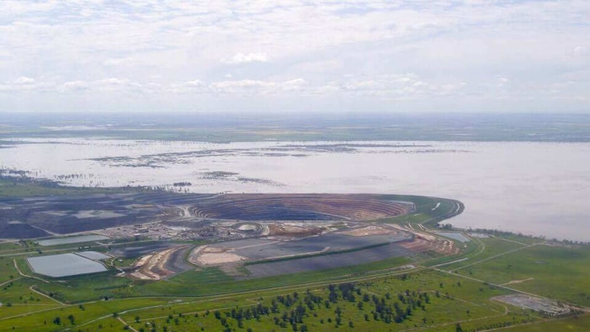 An aerial view of flooding with an open cut mine nearby