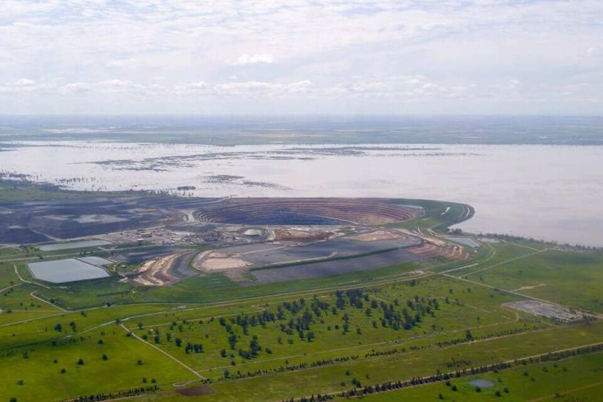 An aerial view of flooding with an open cut mine nearby