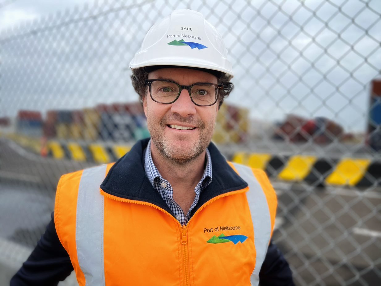 Saul Cannon, wearing a high-vis vest and hard hat, smiles widely.