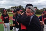 Chris Lane's dad hugs an Essendon baseballer on a baseball field